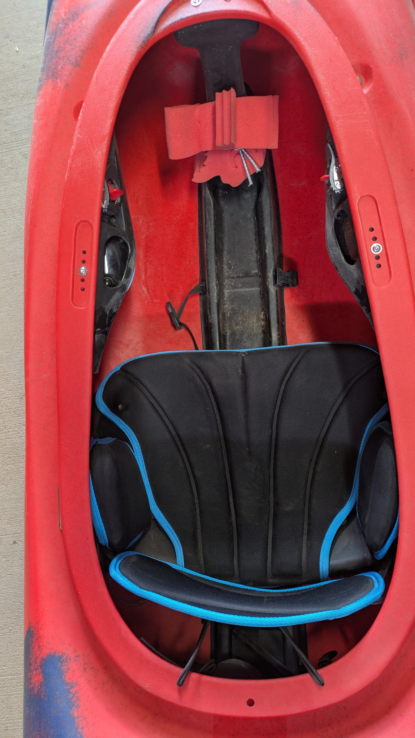 Top-down view of the Pyranha Demo Scorch X kayak interior, featuring a seat with black padding and blue trim, footrests, and detailed cockpit—perfect for anyone seeking a quality used or demo boat.