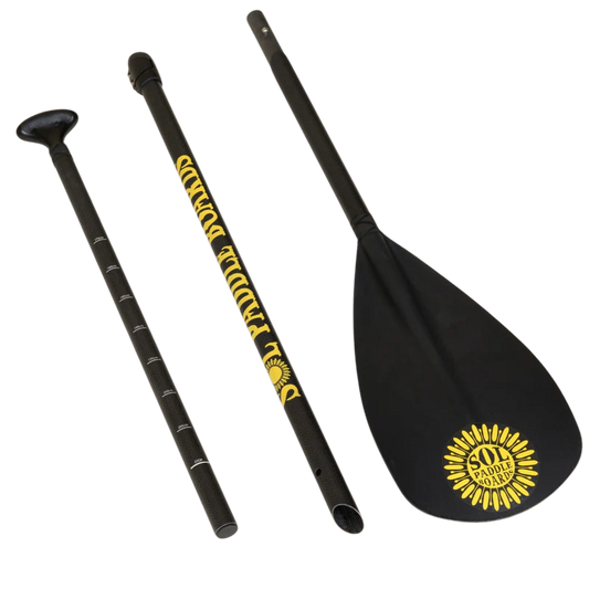 The three-piece black Carbon Blaster SUP Paddle from SOL Paddle Boards, adorned with a yellow sun and "Soul Paddle" text, easily converts for kayak use—making it a versatile accessory for paddle board or SOL Carbon Blaster adventures.