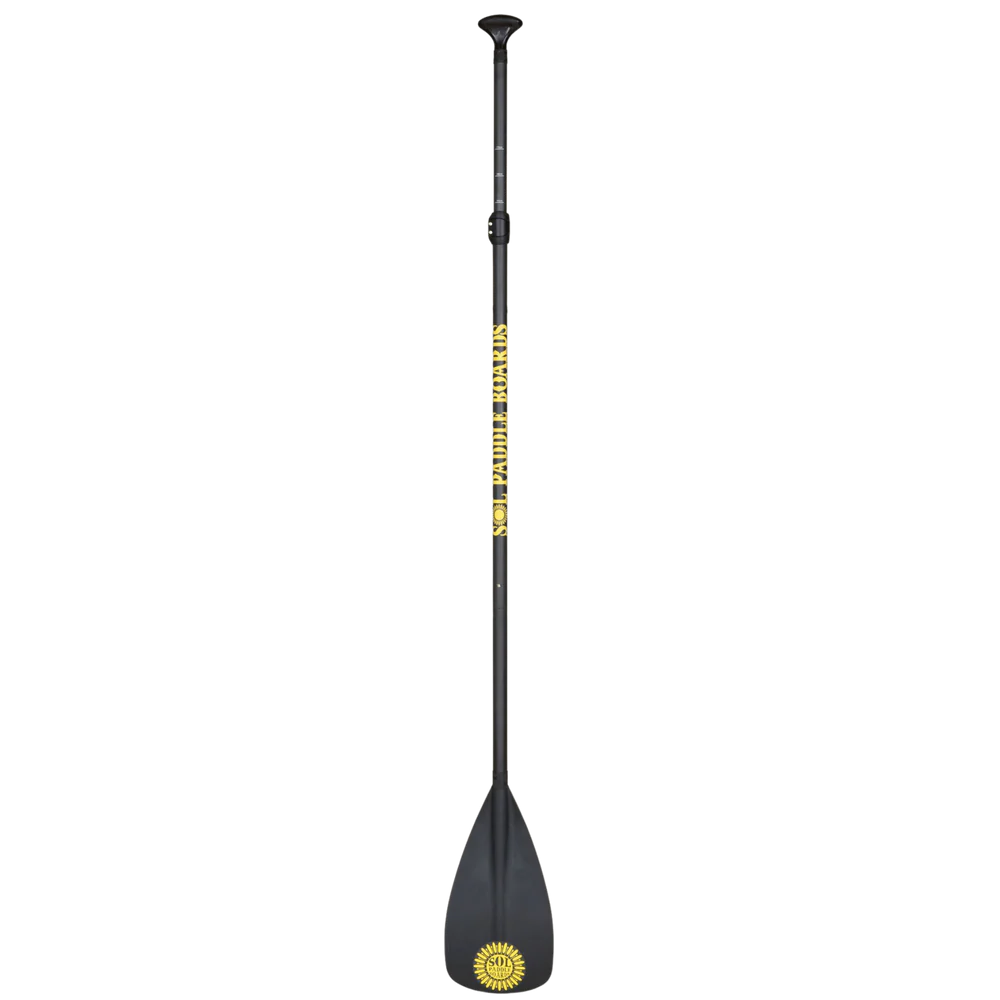 The Carbon Blaster 3-Piece Travel SUP Paddle by SOL Paddle Boards is black with a yellow sun logo and "GLOBAL BREAKERS" on the carbon shaft, featuring an ergonomic handle, wide flat blade, and adjustable length for convenience.