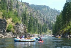 a group of people are rafting down a river.