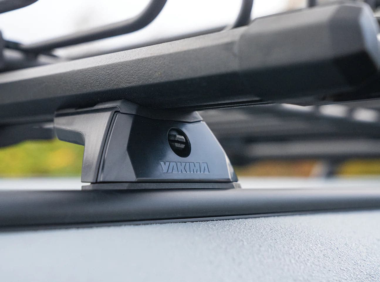 a black car with a Yakima TrackTower roof rack attached to it.