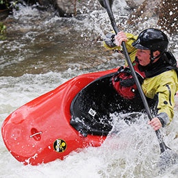 a man in a red kayak in the water.