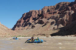 a group of people riding in rafts on a river.
