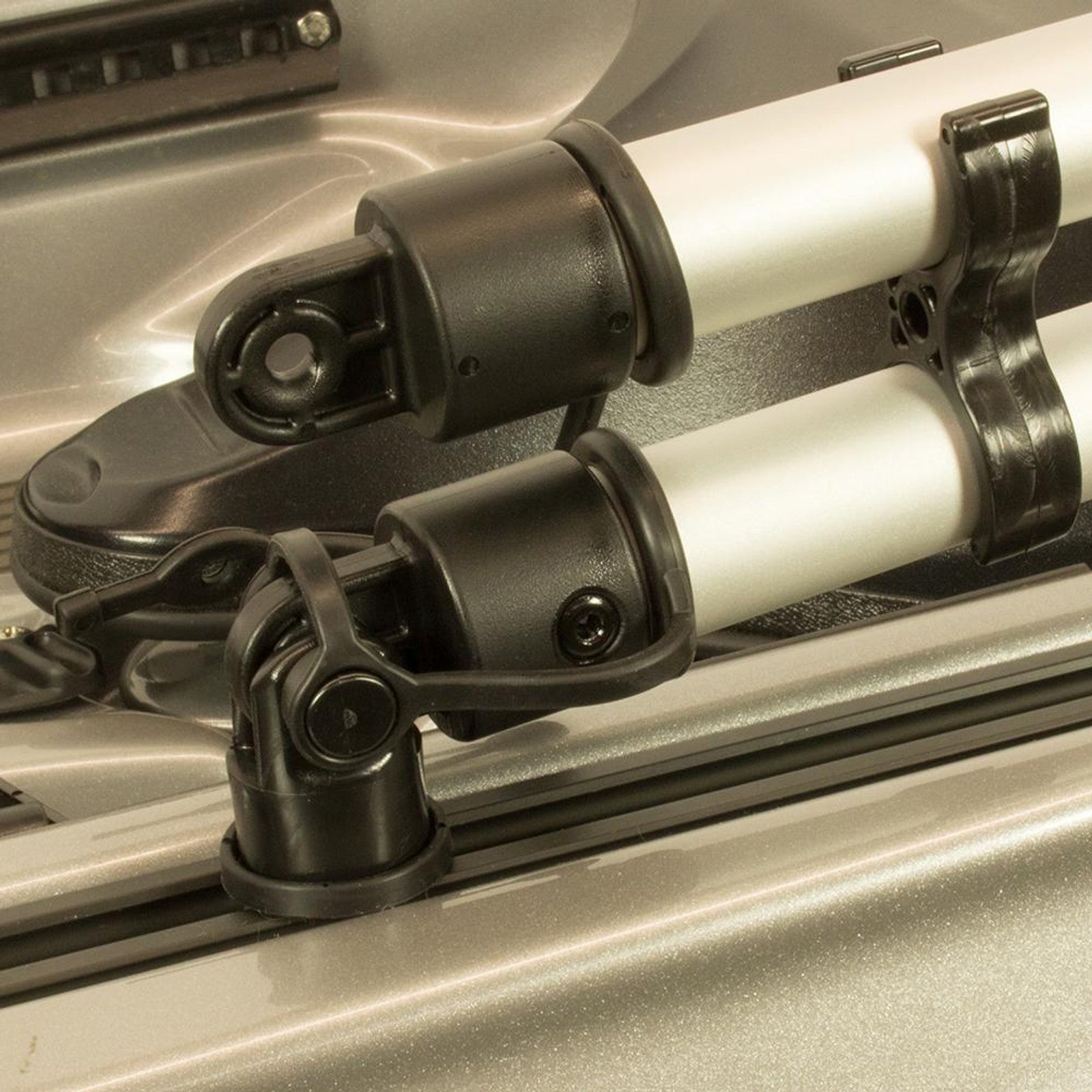 Close-up of YakAttack CommandStand Track Mount Kit's black and silver adjustable support arms with pivot joints, securely attached to a metallic surface for reliable kayak track compatibility.