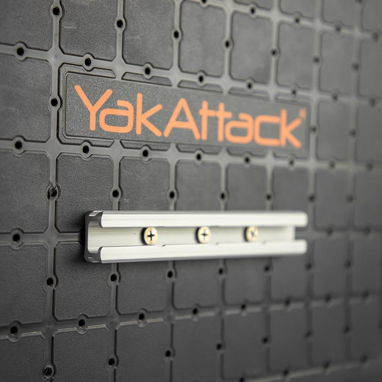 Close-up of a YakAttack GearTrac mounting panel with an aluminum rail securely fastened by four screws, highlighting premium kayak mounting solutions.