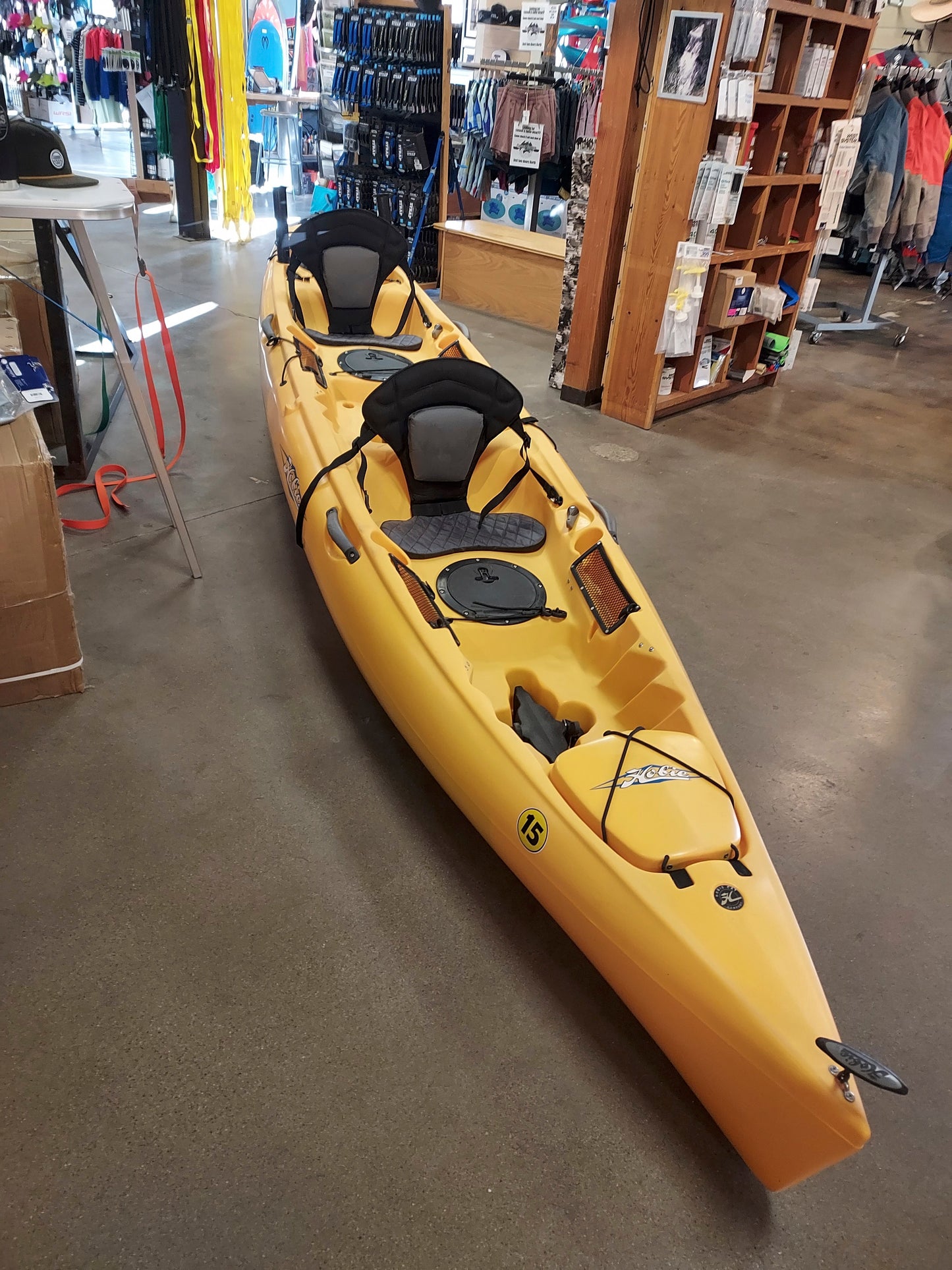 A yellow Consignment Hobie Mirage Oasis kayak sitting in a 4CRS store.