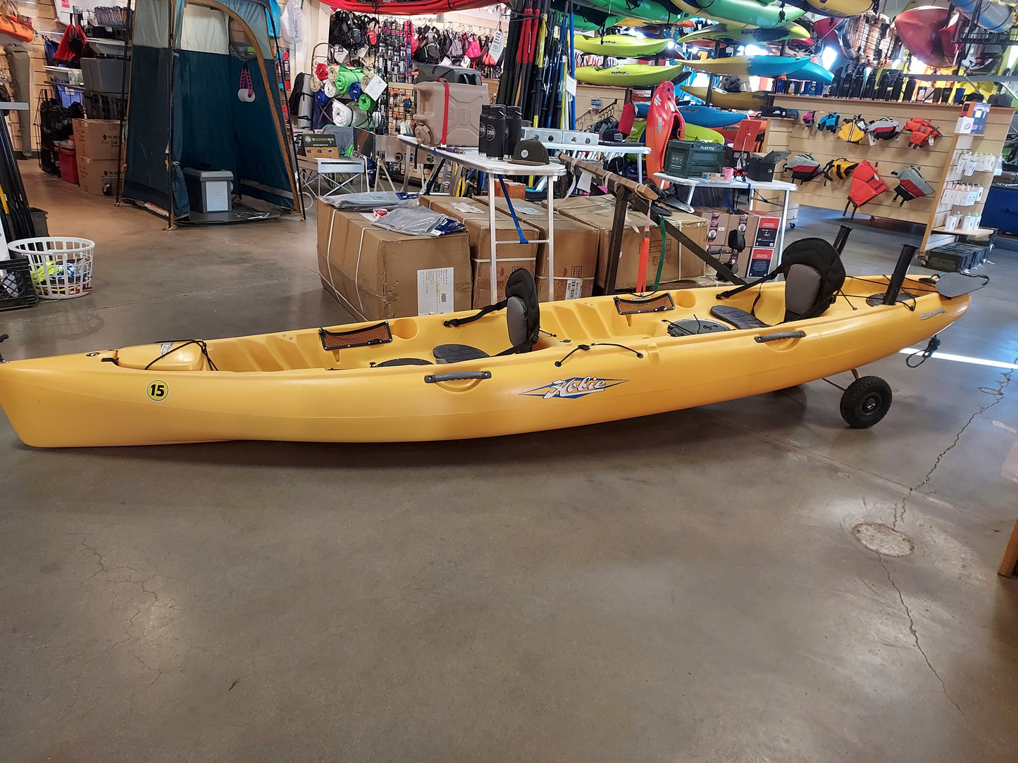 A yellow Consignment Hobie Mirage Oasis kayak sitting in a 4CRS store.