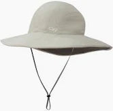 The Oasis Sun Sombrero by OR is a wide-brimmed, light gray sun hat with UPF 50+ sun protection, featuring a chin strap and a small front logo.