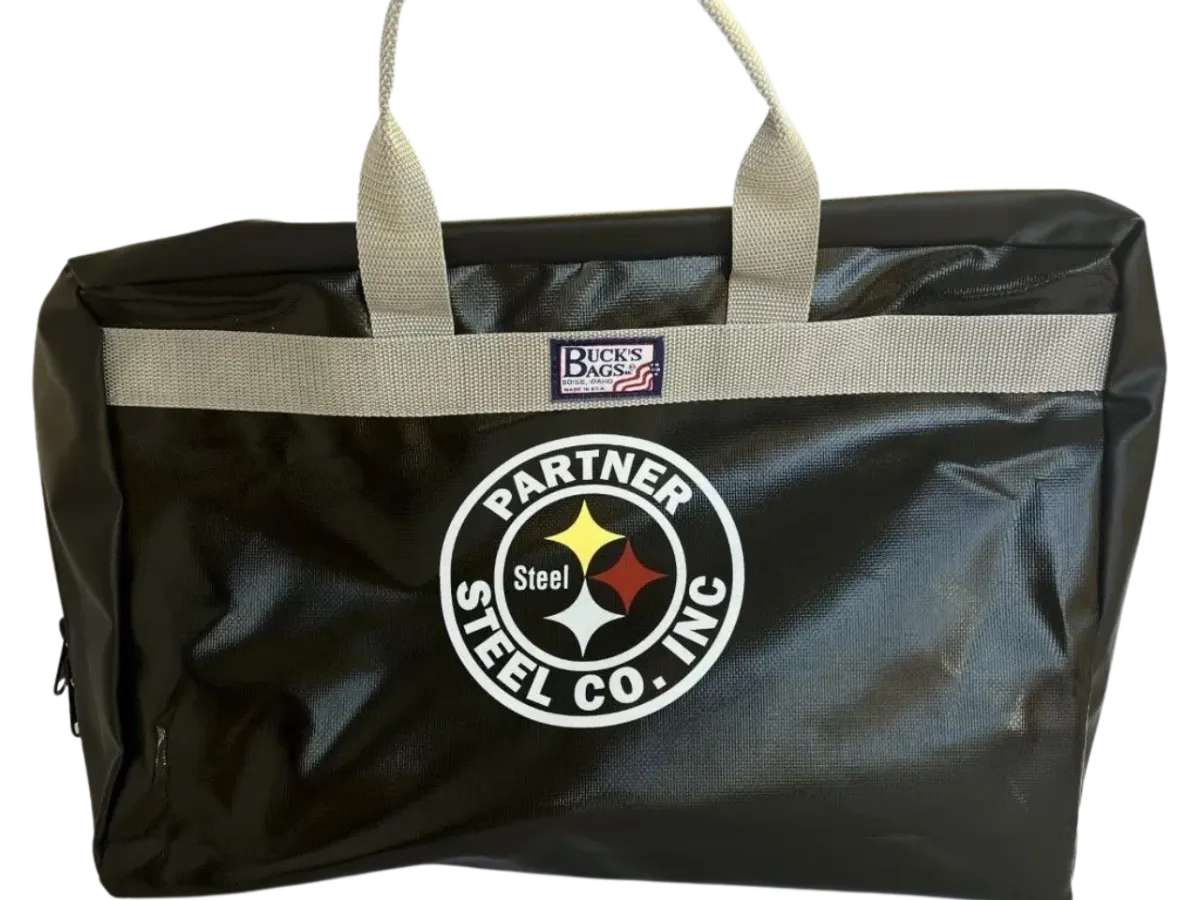 A large black bag with gray handles, featuring a circular logo of "Partner Steel" and another patch displaying "Durable custom sized Buck's Bags" to protect the Stove Bags.