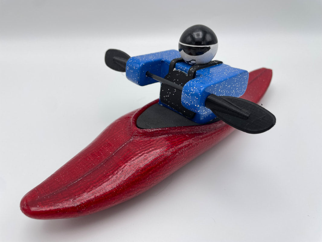 Part of the Foamie Friends lineup, the Foamie Half-Slice features a toy kayaker wearing a black helmet and holding blue paddles, seated in a red kayak and primed to explore water dynamics during river play.