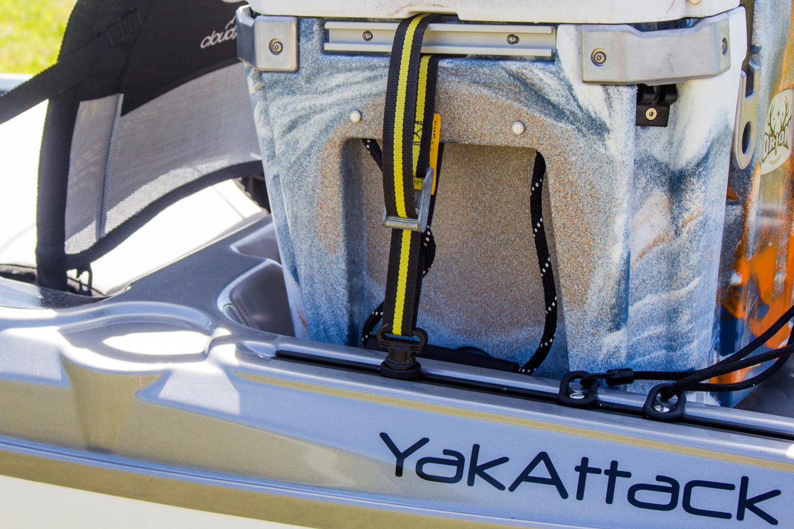 A YakAttack cooler is secured to a kayak with YakAttack Vertical Tie Down - Pair and features GearTrac kayak track systems for versatile mounting.