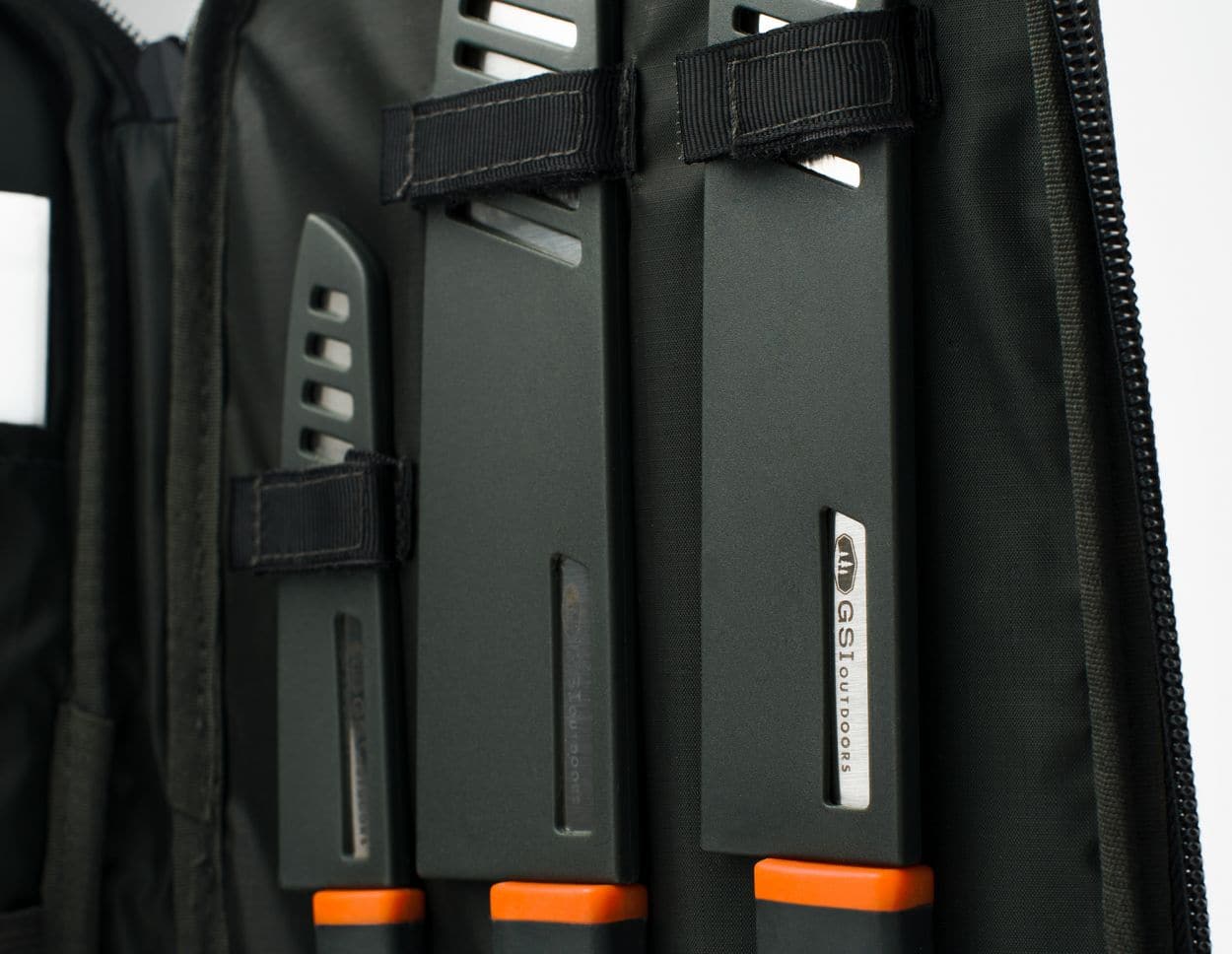 A sleek black carrying case from GSI Outdoors holds the premium Santoku Knife Set, featuring three knives with protective covers.