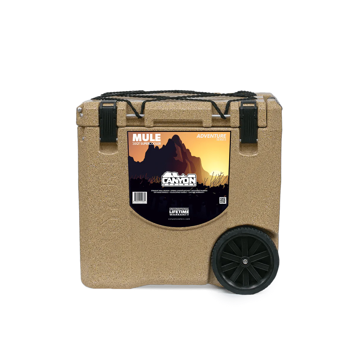 The Canyon Coolers Mule 30 Cooler in tan is a wheeled unit with hard wheels and a mountain graphic. It has two black latches, a sturdy side handle for easy transport, and a jungle bungee strap to secure essentials for adventures.