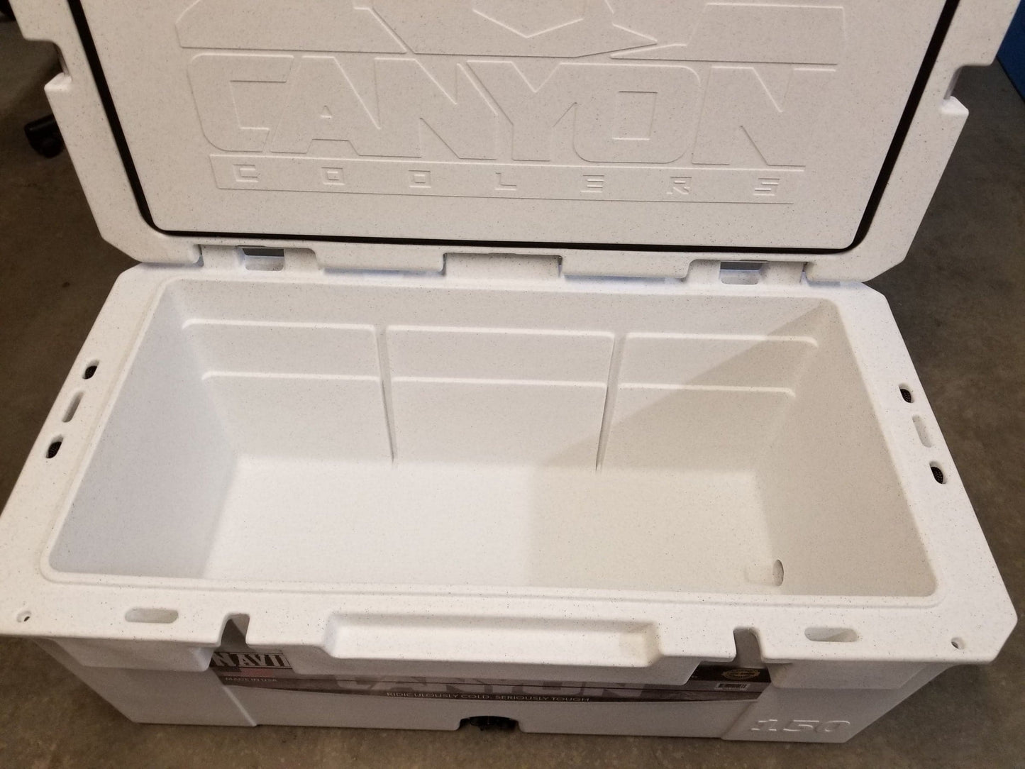 The Navigator Pro 150 Raft Cooler by Canyon Coolers features an open white design with a textured interior and "Canyon Coolers" embossed on the lid, highlighting its expert rotomolded construction. It includes a lifetime warranty for lasting peace of mind.