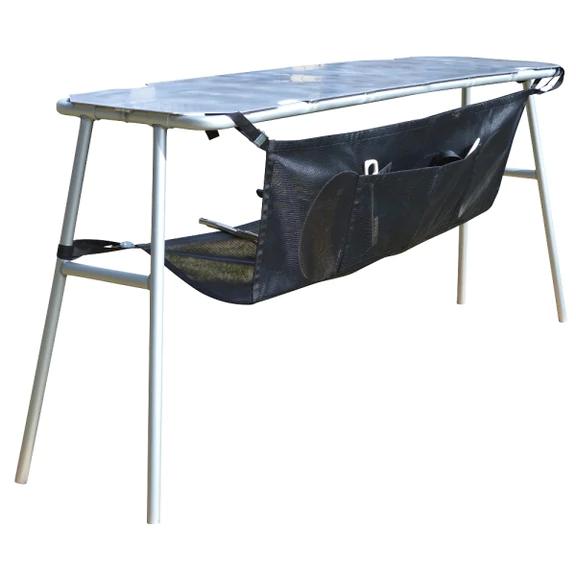 Folding camping table with a black storage organizer attached below the tabletop. The table has white metal legs and a grey surface.