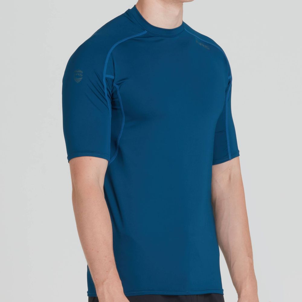 A man wears the NRS Short-Sleeve Rashguard against a plain background, highlighting its sun protection and moisture-wicking features; only his upper body is visible.