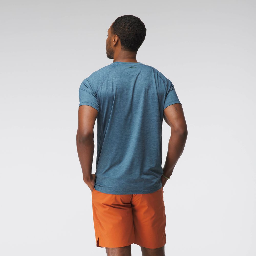 A person in an NRS Silkweight Short-Sleeve Shirt - Men's in aqua blue and orange shorts stands back to the camera against a white background, enjoying the sun protection and moisture-wicking features of the fabric.