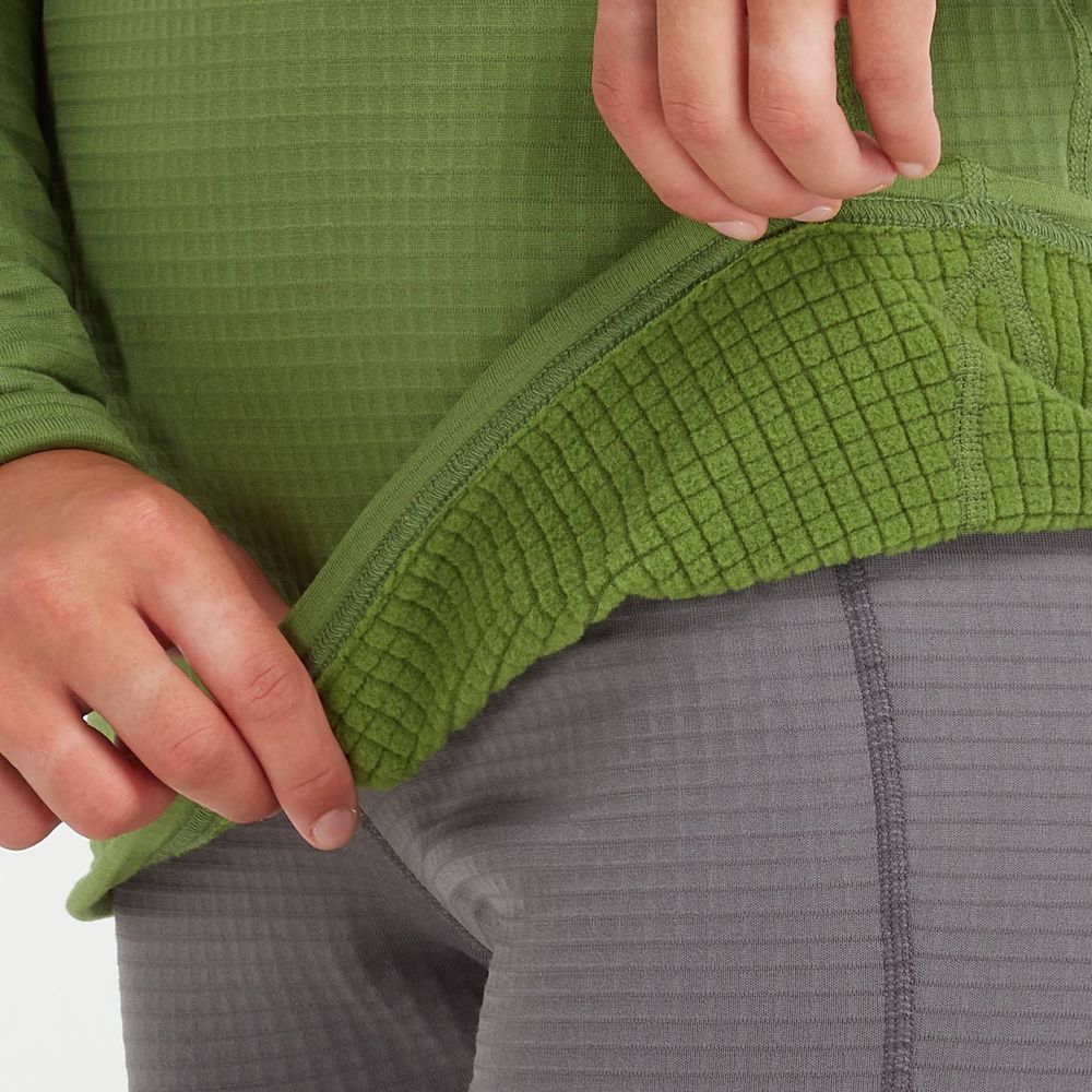 A person pulls up the hem of an NRS Lightweight Shirt - Women's revealing a grid pattern lining with moisture-wicking properties, stylishly paired with gray textured pants.