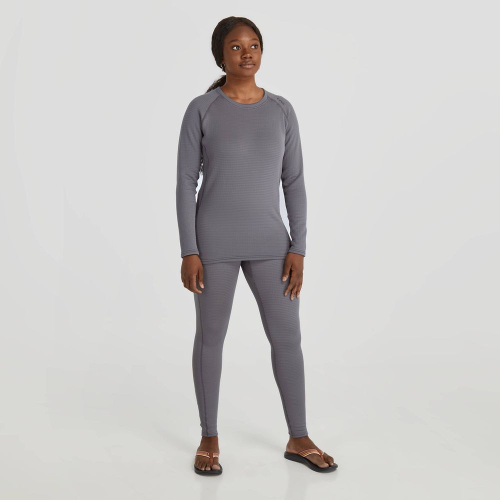 A person stands against a plain white background in NRS's gray moisture-wicking Lightweight Shirt - Women's, paired with leggings and sandals for added comfort and style.