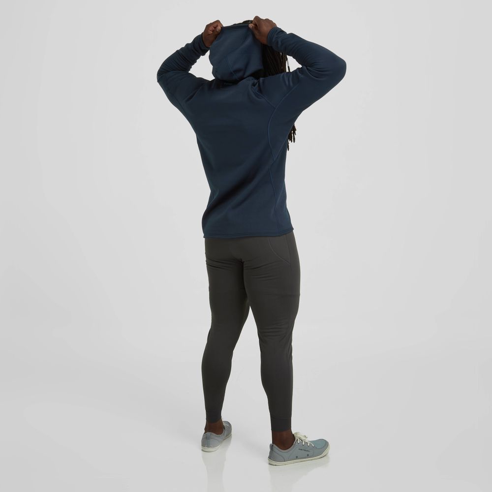A person in a navy hoodie and NRS Men's Expedition Weight Pants stands with their back to the camera, adjusting the hood. The high-stretch fleece material and gasket-friendly cuffs enhance comfort, perfect for any adventure.