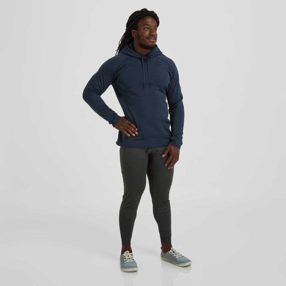 A man stands wearing a dark blue hoodie with gasket-friendly cuffs, NRS Expedition Weight Pants - Men's in gray, and sneakers against a plain white background.