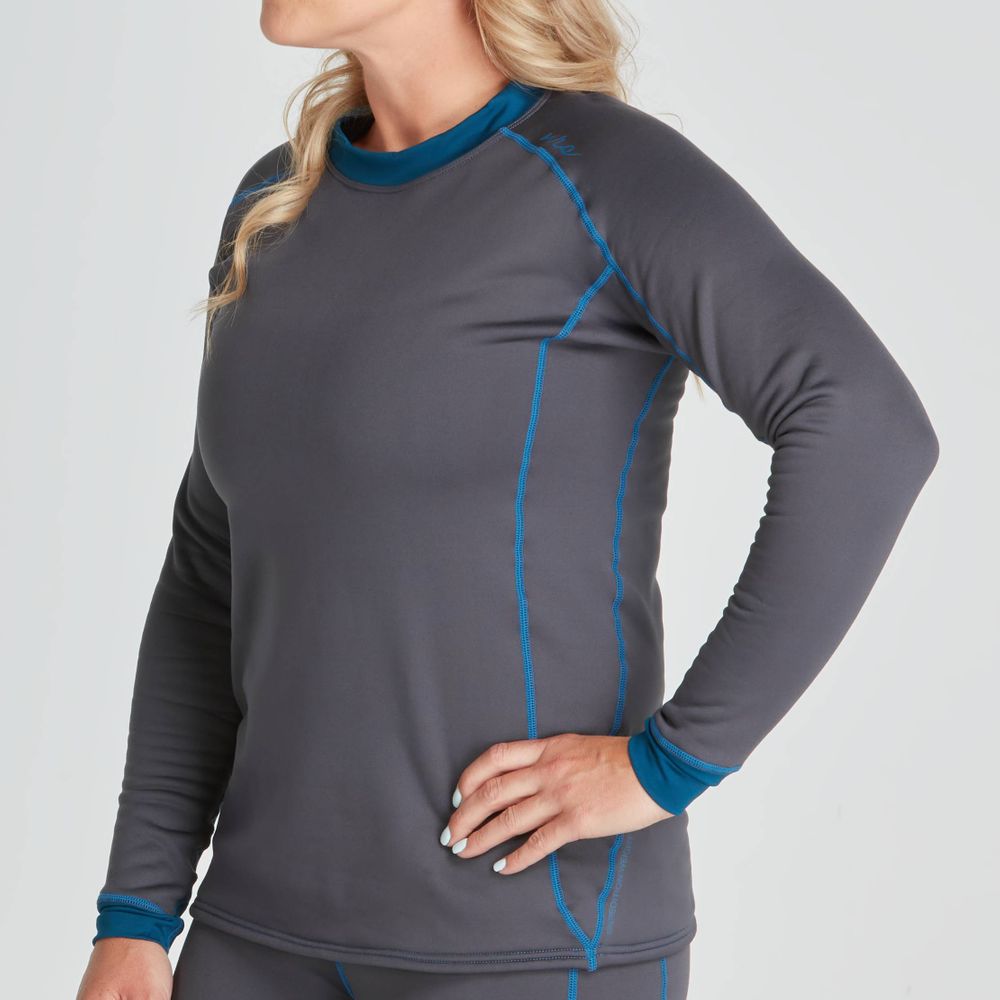 A person wearing the NRS Expedition Fleece - Women's, a gray long-sleeve athletic top with blue accents made from recycled material, stands against a neutral background.