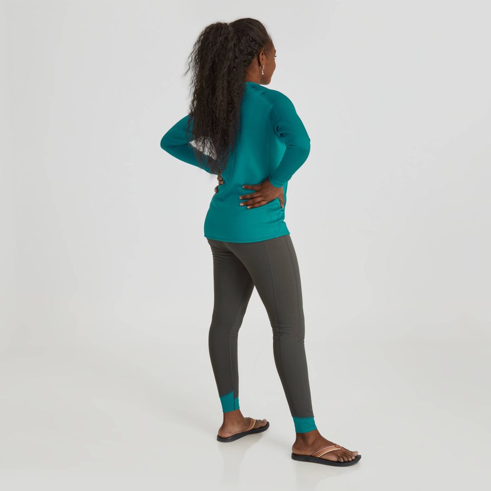 A person in an NRS Expedition Weight Pants - Women's stands hands on hips, facing away, showcasing the high-rise waist for both style and comfort.