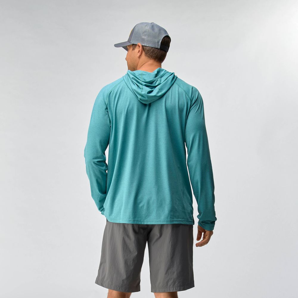 A man wearing the NRS Silkweight Hoodie - Men's in teal, paired with gray shorts and a gray cap, stands facing away against a plain light background.