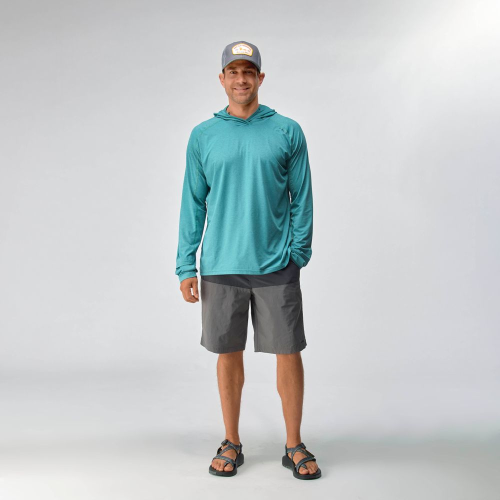 A man faces forward against a plain white background, wearing the NRS Silkweight Hoodie - Men's in blue, paired with gray shorts, gray cap, and sandals.