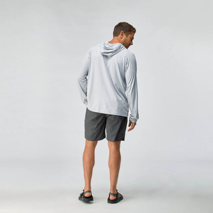 A man faces away, wearing the NRS Silkweight Hoodie - Men's in light gray for sun protection, paired with dark gray shorts and black sandals against a plain light background.