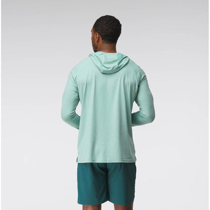 A man faces away from the camera wearing the NRS Silkweight Hoodie - Men's in light green and dark green shorts, set against a plain background—ideal for sun protection and moisture wicking.