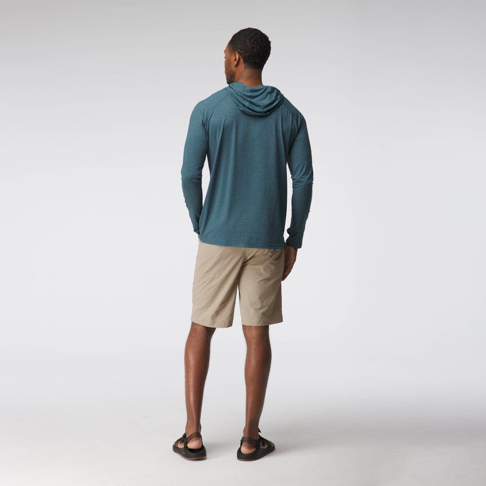 A man faces away, wearing the NRS Silkweight Hoodie - Men's in teal with beige shorts and sandals, set against a plain light background.