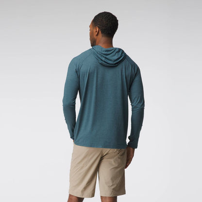 A man faces away, wearing an NRS Silkweight Hoodie - Men's in teal with sun protection and beige shorts, set against a plain light background.