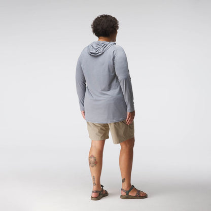 A woman models the NRS Silkweight Hoodie in light gray with beige shorts and sandals, standing against a plain white background to highlight stylish sun protection.