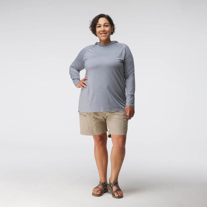 A woman faces forward against a white background, wearing the NRS Silkweight Hoodie for women in light gray, paired with khaki shorts and sandals.