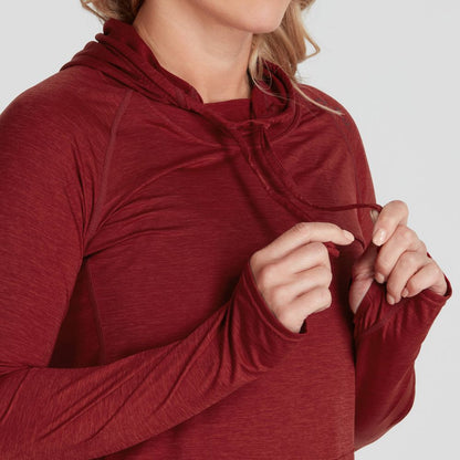 A woman wearing an NRS maroon Silkweight Vesi Hoodie, made from recycled materials, adjusting the hood strings with both hands.