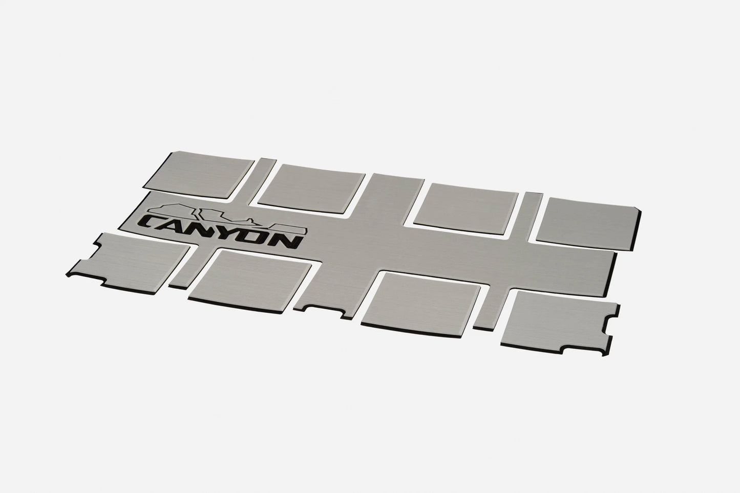 A rectangular metal sheet featuring "CANYON" and a mountain graphic, designed to complement your Canyon Coolers Traction Pads for enhanced grip and style.