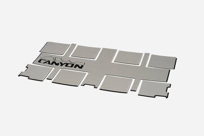 A rectangular metal sheet featuring "CANYON" and a mountain graphic, designed to complement your Canyon Coolers Traction Pads for enhanced grip and style.