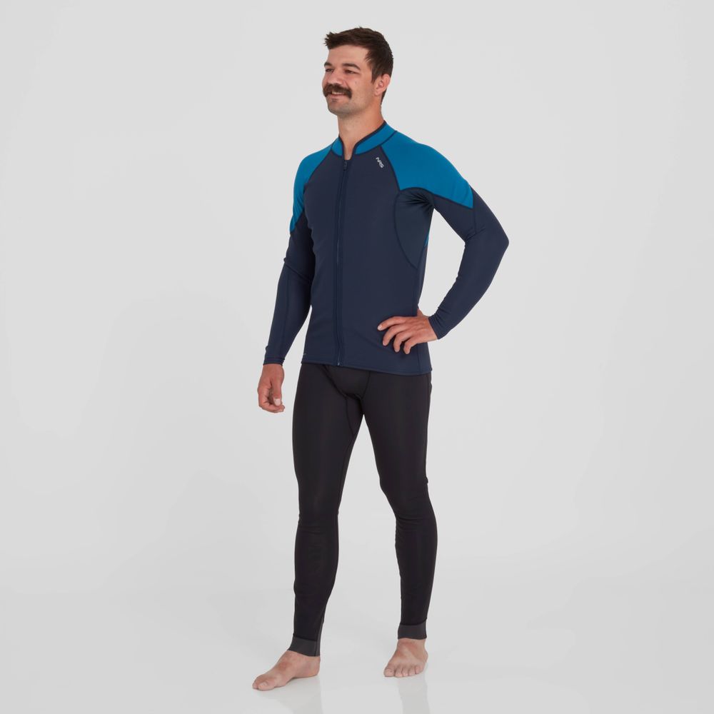 A man stands barefoot against a white background, wearing the NRS Hydroskin 0.5mm Jacket in blue and black.