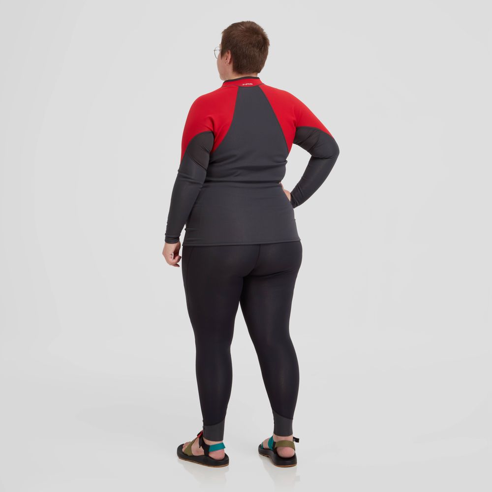 A person wearing the NRS Hydroskin 0.5mm Jacket known for enhancing paddling performance, and black sandals stands facing away against a plain white background.
