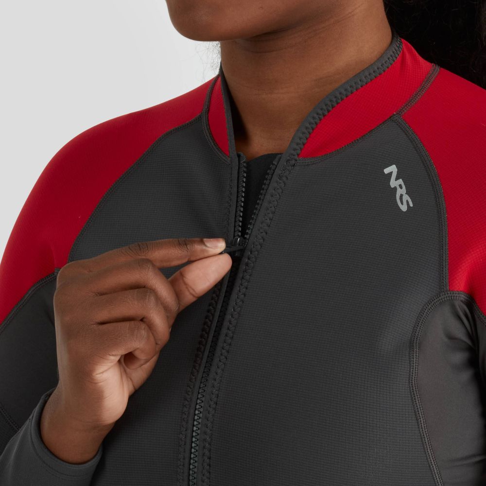 A person in the NRS Hydroskin 0.5mm Jacket for women, which is grey and red neoprene, partially unzips the front to enhance paddling performance.