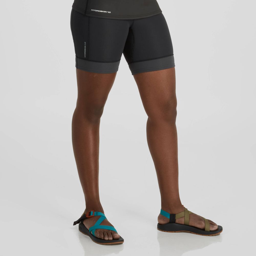 A woman wearing NRS HydroSkin 0.5mm Shorts - Women's and a tee shirt.