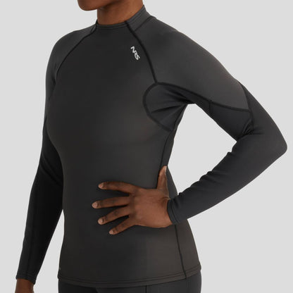A person wears an NRS Hydroskin 1.0mm Long Sleeve Women's Shirt, featuring a snug wet-suit style fit and neoprene protection, with one hand on their hip against a plain backdrop.