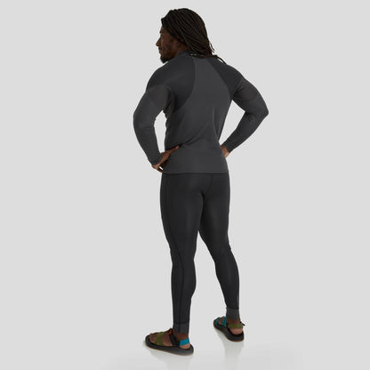 A man in a dark wetsuit stands facing away against a gray background, highlighting NRS HydroSkin 1.5mm Men's Pants which provide warmth and freedom of movement to enhance paddling performance.