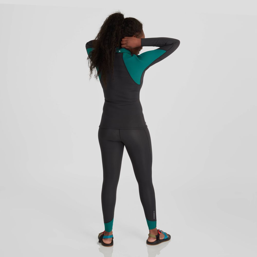 The back view of a woman wearing NRS Hydroskin 1.5 Pants - Women's, a black and green wetsuit layer, during paddling season.
