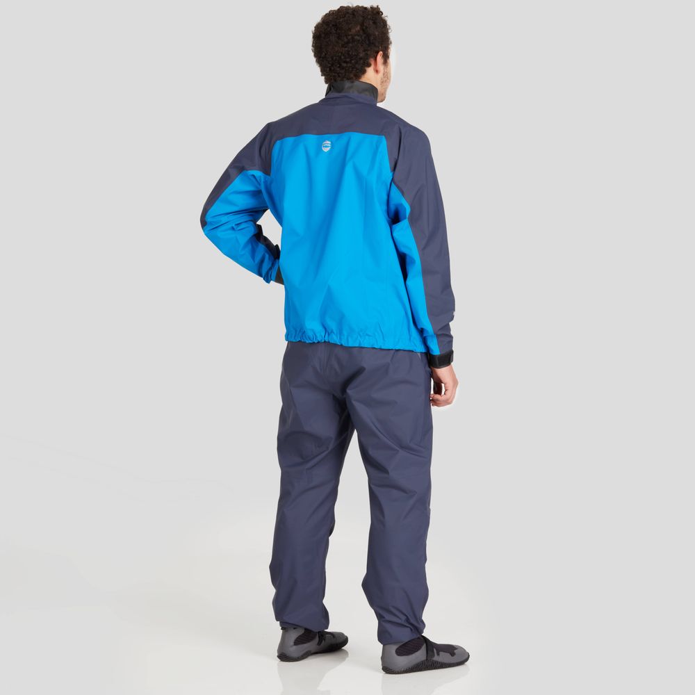 A man models the NRS Endurance Splash Jacket, featuring a blue and gray design reminiscent of a tracksuit, as he stands facing away against a plain light gray background.