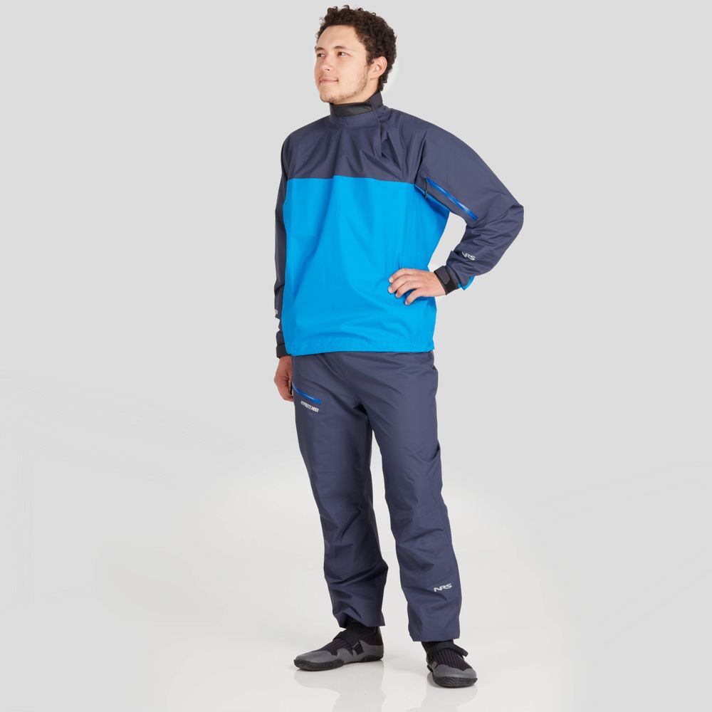 A person proudly models the Endurance Splash Jacket for men by NRS, featuring a stylish blue and dark gray design that stands out against a plain background, perfect for any weather.