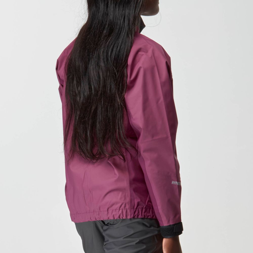 A woman with long dark hair wears the NRS Endurance Splash Jacket - Women's in magenta and dark pants, shown from the back against a plain white background.