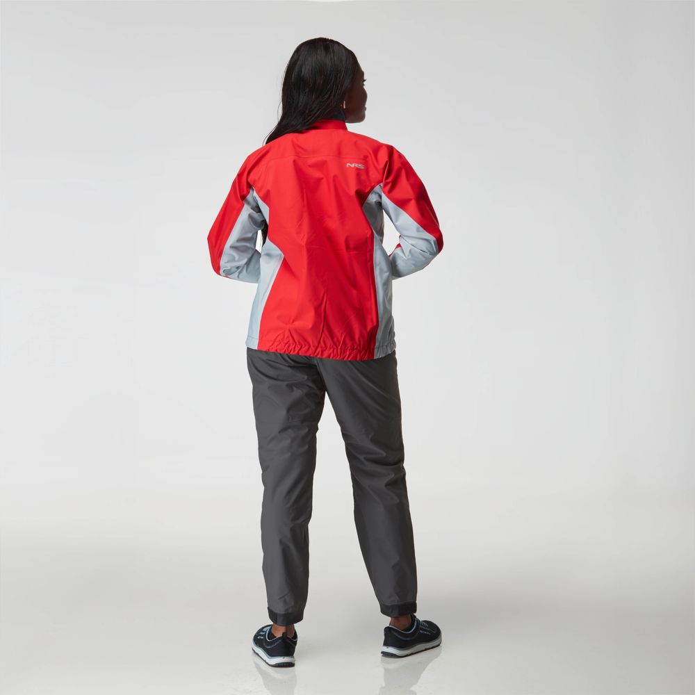 A person faces away, wearing an NRS Endurance Splash Jacket - Women's in red and gray, dark pants, and black sneakers against a plain white background.