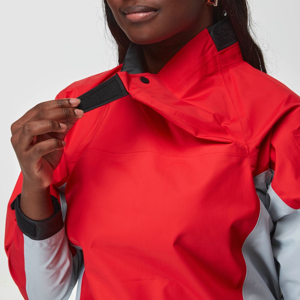 A person fastens the collar of the NRS Endurance Splash Jacket - Women's, a red and gray waterproof jacket, using a Velcro strap.